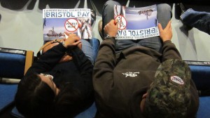 Two activists hold anti-Pebble Mine posters in a back row of the Wendy Williamson Auditorium during an EPA public comment meeting on the Draft Bristol Bay Watershed Assessment.