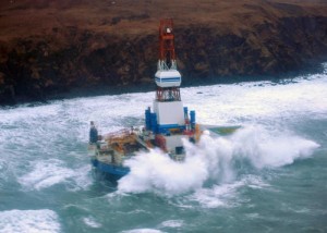 Waves crash over the conical drilling unit Kulluk where it sits aground on the southeast side of Sitkalidak Island, Alaska, Jan. 1, 2013. A Unified Command, consisting of the Coast Guard, federal, state and local partners and industry representatives was established in response to the grounding. U.S. Coast Guard photo by Petty Officer 3rd Class Jonathan Klingenberg.