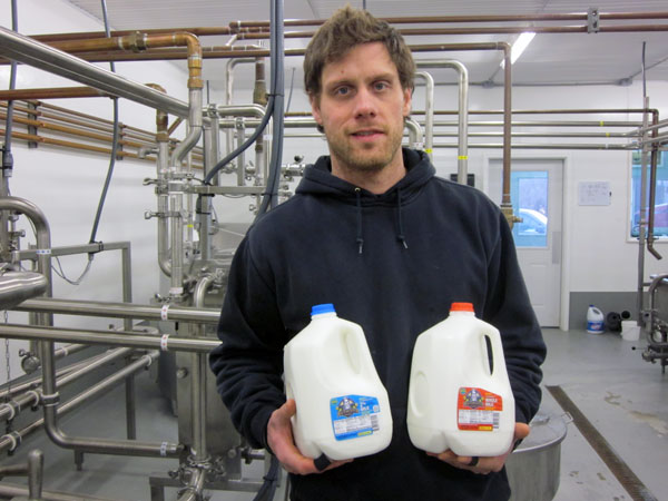 Ty Havermeister in the new Havermeister bottling facilty  with gallons of whole milk and 2% milk now being marketed in Anchorage and in the Valley. Photo by Ellen Lockyer, KSKA - Anchorage.