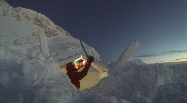 Lonnie building his snow shelter at 14.2K with Denali’s summit ridge in the background. Photo courtesy of Lonnie Dupre.