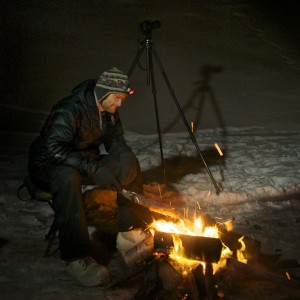 Aurora Hunter Todd Salat sitting around the campfire, waiting for the auroras to come out.