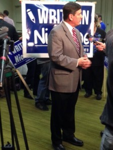 Anchorage Mayor Dan Sullivan stands in front of a 'Write in Nick Moe' campaign sign at Dena'ina Center where he talked with TV reporters about election results. Photo by Daysha Eaton, KSKA - Anchorage.