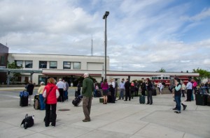 Dozens of people and their luggage waiting in the parking lot. (Photo by Heather Bryant/KTOO)