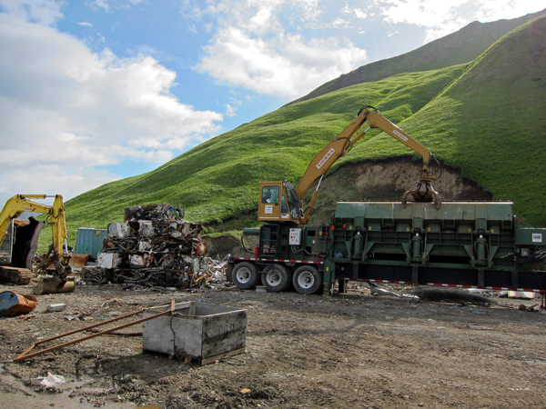Crushed scrap sits next to Ron Moore's metal compactor. (Audrey Carlsen/KUCB)