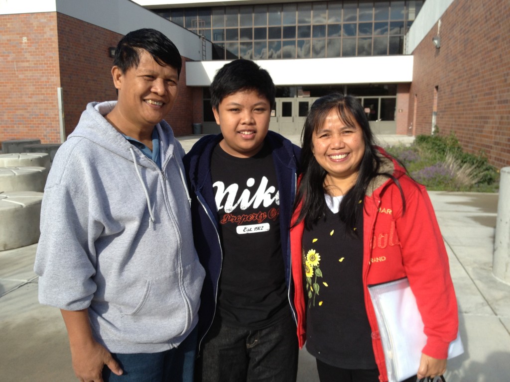 8th Grader Nester Cunanan III stands in front of Mears Middle School in South Anchorage with his mother, Natalia Cunanan and his father Nester Cunanan Jr.