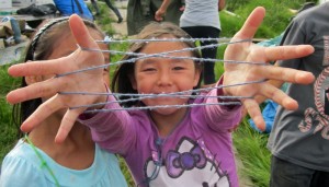 Third grader Judith Allen practices string games with friends at the culture camp near Kiana. Photo by Daysha Eaton, KSKA - Anchorage.