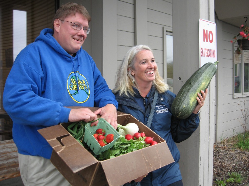 Reps. Bill Stoltze and Cathy Munoz display vegetables grown in Palmer during a legislative tour of Matanuska Valley farms earlier this month. Photo by Ellen Lockyer, KSKA - Anchorage.