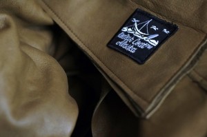 The Kodiak Coat label is sewed onto a leather jacket in Milligan’s workshop. Photo by Annie Bartholomew/KTOO