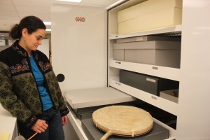 Alaska State Museum conservator Ellen Carrlee wants to ensure a walrus stomach drum from the 1974 Arctic Games remains unharmed during the move to the new building. Photo by Lisa Phu, KTOO - Juneau.
