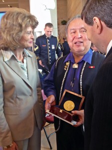 Ozzie Sheakley hold the Congressional Gold Medal awarded to the Tlingit Tribe for code talking service during World War II. He speaks to Sens. Lisa Murkowski and Mark Begich after the ceremony. Photo by Liz Ruskin, APRN - Washington DC.