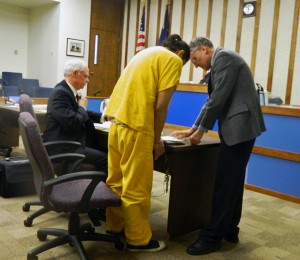 William Buxton signs and places his fingerprint on a document following his sentencing hearing Thursday in Ketchikan Superior Court. Also standing is District Attorney Steve West. Seated is defense attorney Sam McQuerry,