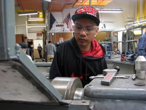 Mark Partido operates a metal lathe in the school's metal shop. Photo by Robert Woolsey, KCAW - Sitka.