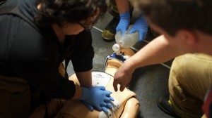 Juneau Empire reporter Emily Russo Miller performs chest compressions on a dummy during a CPR training exercise at Hagevig Fire Training Center. (Photo by Annie Bartholomew/KTOO)