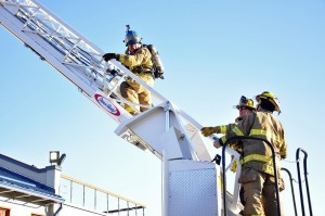 KTOO reporter Matt Miller climbs the ladder during the morning training at Hagevig Fire Training Center. (Photo by Annie Bartholomew/KTOO)