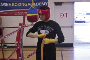 Nino Delgado wraps up his hands and wrists while preparing to spar. (Photo by Josh Edge, APRN - Anchorage)