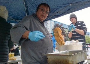 Garfield Katasse shows off a hot, fresh piece of fry bread. (Photo by Jeremy Hsieh/KTOO)