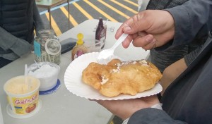 Darrin Austin puts butter and powdered sugar on his fry bread. (Photo by Jeremy Hsieh/KTOO)