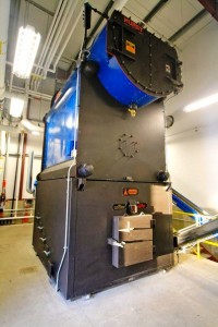 This biomass-fueled boiler at Tok School burns chipped timber waste to generate heat and electricity for the campus. (Credit KUAC file photo)