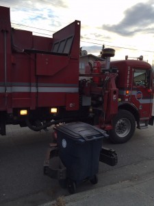 A recycle truck grasps onto a bin in Anchorage. Hillman/KSKA