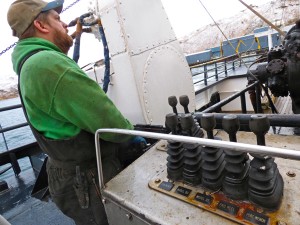 Ron Mitchell drops nets onto the deck of the F/V Seadawn during pollock season. (Lauren Rosenthal/KUCB)