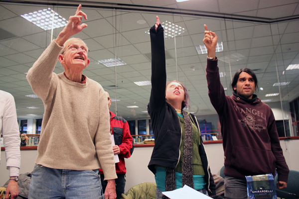 Participants of the Tlingit Language Learners Group point to the ceiling during an exercise called Total Physical Response. (Photo by Lisa Phu/KTOO)