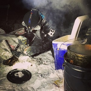 Temperatures of more than 30 below didn't stop Dallas Seavey from mixing up a concoction of fat, meat and kibble for his team after they reached Kaltag. (Photo by Emily Schwing)