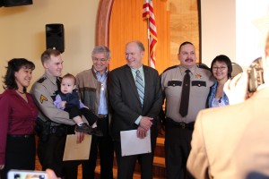 VPSOs Michael Gagliano (second from left) and James Hoelscher (second from right) pose for pictures with their families, Gov. Bill Walker and Lt. Gov. Byron Mallott. (Rachel Waldholz/KCAW)