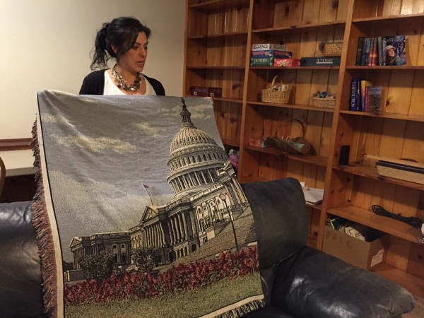 In the den, Kara Nelson holds up a blanket given to Haven House by U.S. Sen. Lisa Murkowski. (Photo by Lisa Phu/KTOO)