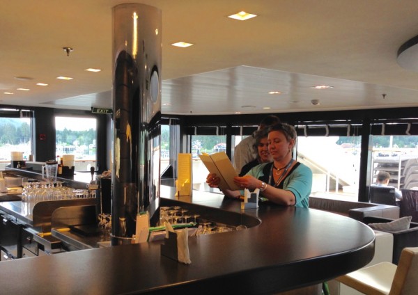 Petersburg chef, Mindy Anderson, and Liz Cabrera with the Petersburg Borough check out a menu at one of the ship’s bars. Photo/Angela Denning