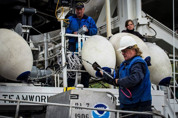 Chief Bosun Jim Kruger (front) works with Jason Kinyon and Lindsey Houska on the NOAA ship Rainier to prepare for the summer’s first Arctic survey project, in Kotzebue Sound. (Photo: Courtesy of NOAA)
