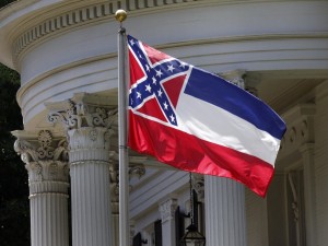 The state flag of Mississippi is unfurled against the front of the Governor's Mansion in Jackson. Photo via NPR.