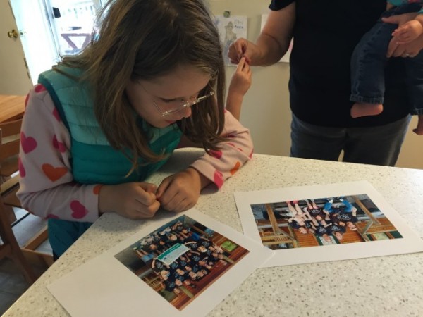 Elena Lohrey, 12, looks at pictures from an FASD Family Camp her family attended in Arizona earlier this summer. (Photo by Lisa Phu/KTOO)