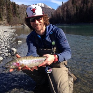 Fly fisher Theronn King holds an early season trout hooked on the Kenai in May. Photo by Michael Forbes.