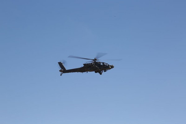 An Army AH-64 Apache Helicopter flies over U.S. Army Soldiers from Delta Company, 1st Battalion, 66th Armored Regiment, 3rd Brigade Combat Team, 4th Infantry Division while conducting mission rehearsals during Decisive Action Rotation 15-02 at the National Training Center in Fort Irwin, Calif., on Nov. 17, 2014. The Decisive Action training environment was developed in order to create a common training scenario for use throughout the Army. (U.S. Army photo by Sgt. Charles Probst/Released)