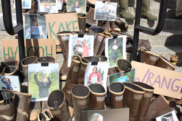 About a hundred pairs of the brown rubber boots along with photos of Alaskans were on the steps of the Capitol building to protest mines in British Columbia. Photo: Lisa Phu/KTOO.