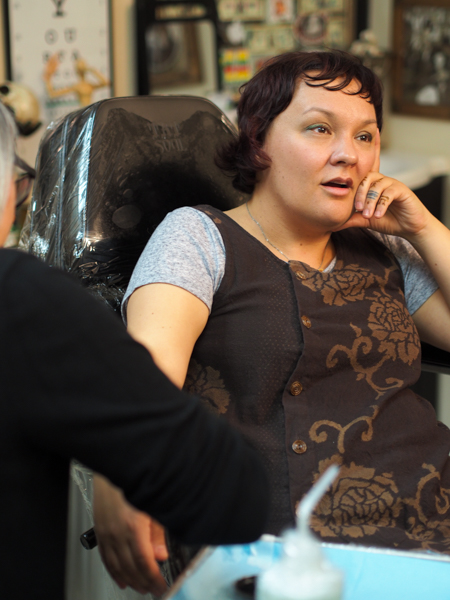 Holly Mititquq Nordlum, originally from Kotzebue, sits for a tattoo along her wrist from Greenlandic artist Maya Sialuk Jacobsen during a live demonstration of traditional tattooing techniques. (Photo: Zachariah Hughes, KSKA).