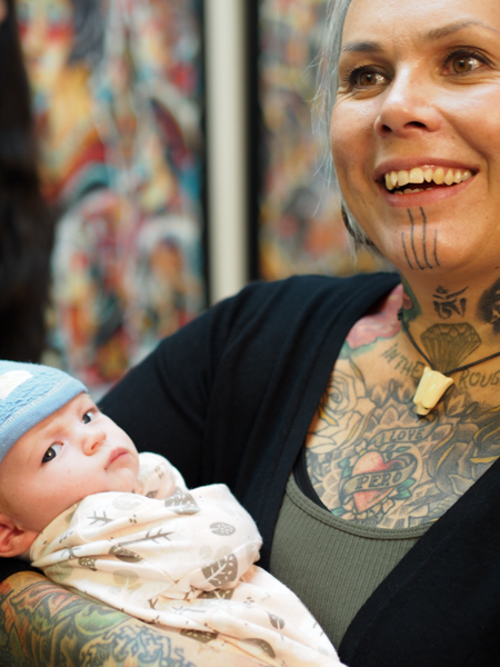 Jacobsen took a break to give Nordlum a rest mid-way through the tattooing demonstration, and everyone in the room took turns passing around an infant that friends had brought to the demonstration. (Photo: Zachariah Hughes, KSKA)