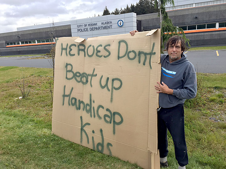 Kodiak resident Brent Watkins silently demonstrated outside the Kodiak Police station Friday, Sept. 18, 2015, two days after a friend with learning disabilities was contacted by three Kodiak Police officers. (Photo by Jay Barrett/KMXT )