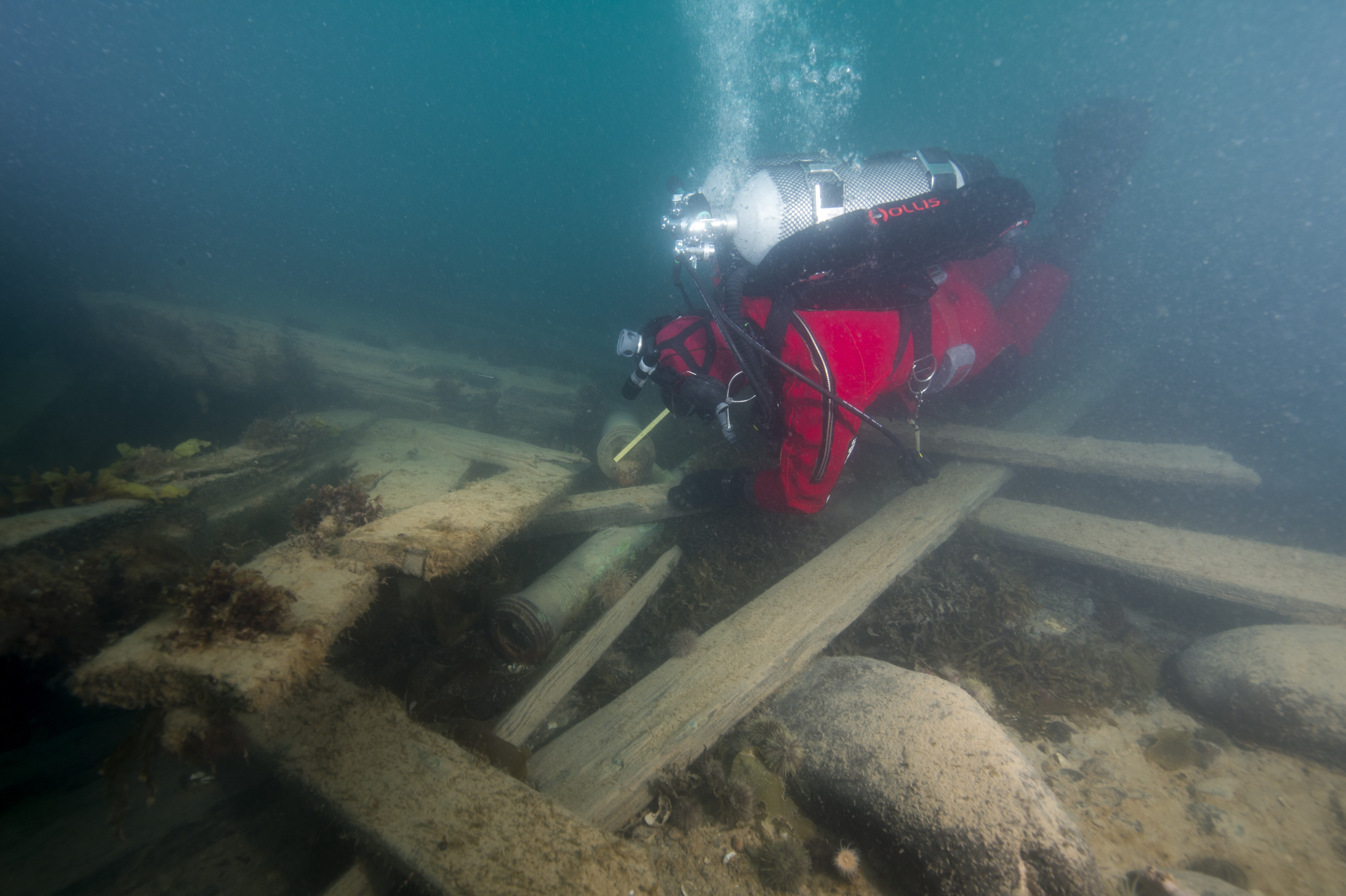 Cannons and loose timbers on the starboard stern.  Diver Filippo Ronca taking measurements at the muzzle. (Photo Courtesy of WGBH.)