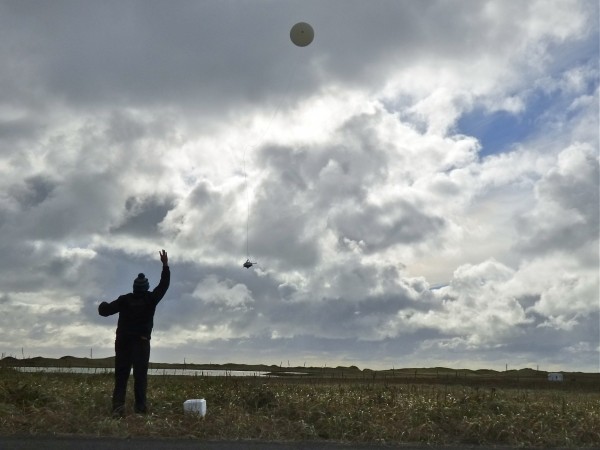 William Wells releases a weather balloon on Alaska's St. Paul Island. (KUCB/John Ryan photo)