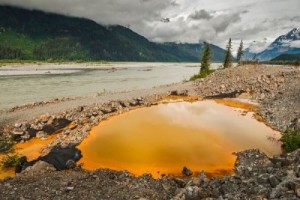 Acidic drainage from the Tulsequah Chief Mine, discolors a containment pond next to the Tulsequah River in British Columbia in 2013. (Photo courtesy of Chris Miller/Trout Unlimited)