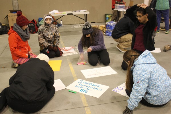 During the sleep-out, students made signs about youth homelessness that they waved outside Mendenhall Mall and Safeway. (Photo by Lisa Phu/KTOO)