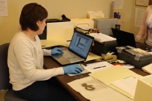 Krystle Weddle, collections fellow, enters information about a metal key into the Sitka Historical Society and Museum’s database. She is performing an audit on the museum’s collection. (Brielle Schaeffer/KCAW photo)
