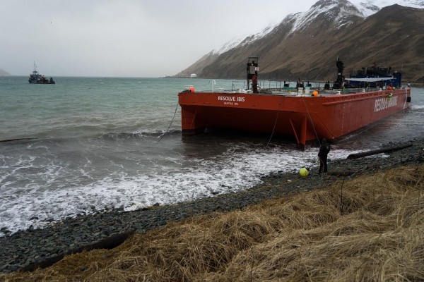 The bright orange Resolve Ibis (far left), an oil spill response barge capable of sopping up over 20,000 gallons of fuel, has a five-year mooring permit from the Alaska Department of Natural Resources. CREDIT ETHAN NICHOLS