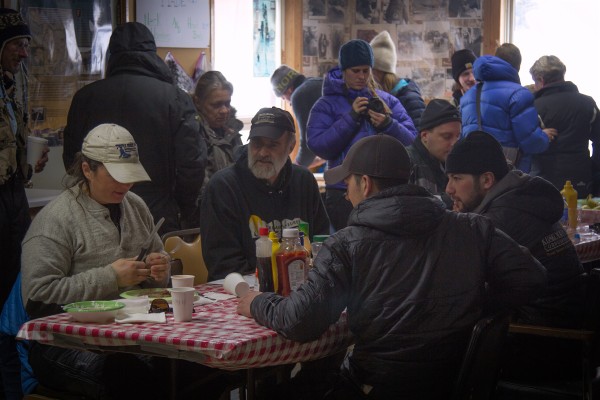 Jessie Royer, left, eats in Takotna with Mark Sass, Brent Sass's father, as well as Richie Diehl and Pete Kaiser. (Photo by Zachariah Hughes/ Alaska Public Media)