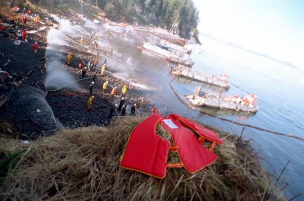 U.S. Navy Mechanized Landing Craft anchored along the shoreline as Navy and civilian personnel position hoses during the Exxon Valdez oil spill clean-up on Smith Island in Prince William Sound, March 24, 1989. (Public domain photo by PH2 POCHE)