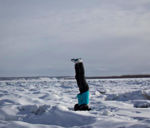 Emily Schwing performs a headstand on the frozen Yukon River. Photo by Zach Hughes/KSKA.