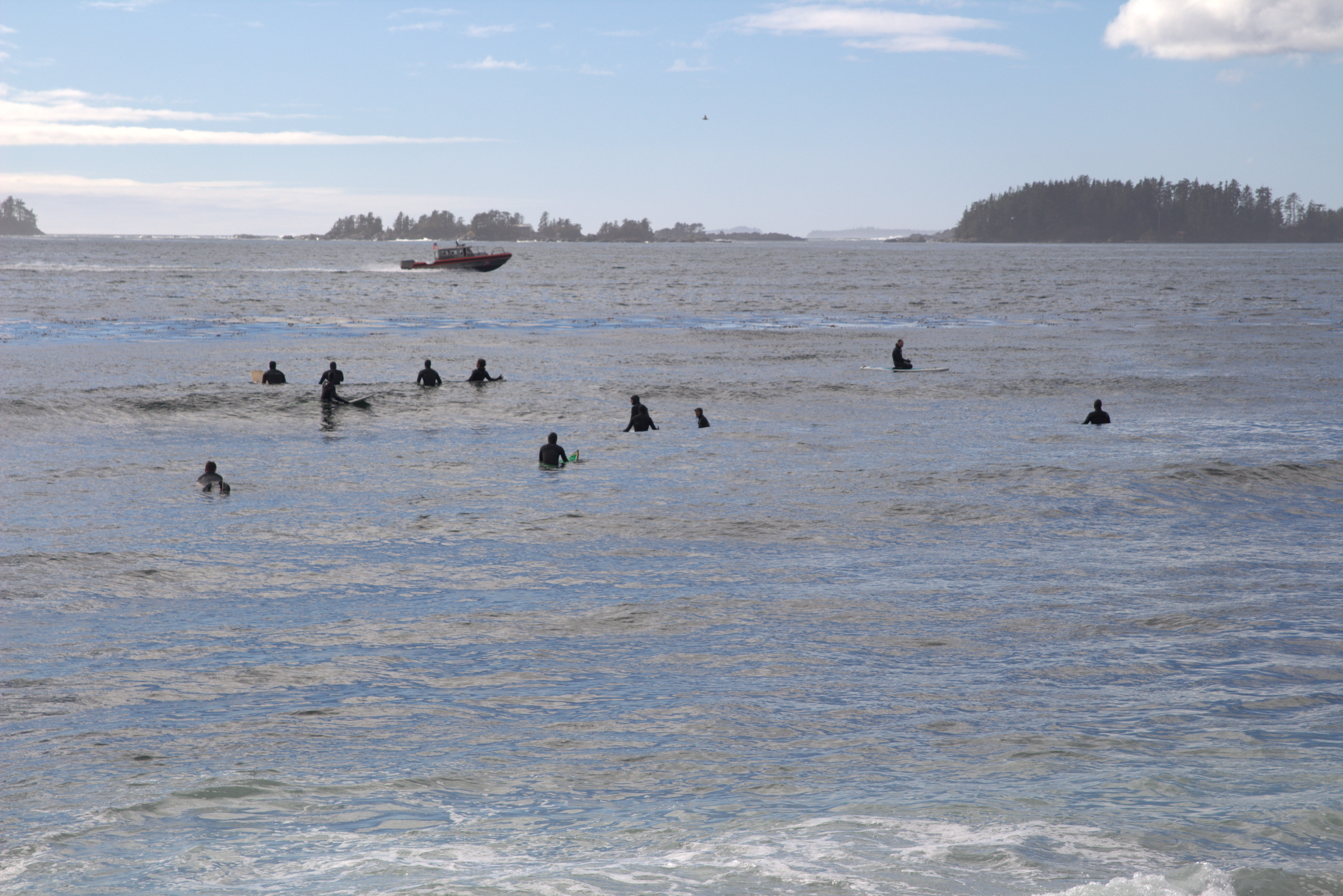 The surf community waits for a break as a boat cruises away from the harbor. (Photo by Brielle Schaeffer,KCAW - Sitka)
