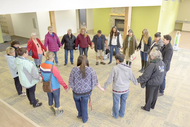 Sharon Isaak (bottom right, grey jacket) leads members of the Kenaitze Indian Tribe's Elders Committee in a closing prayer after the group toured for the first time the tribe's new Elders building on Feb. 11, 2016. (Photo courtesy of Scott Moon with the Kenaitize Indian Tribe)