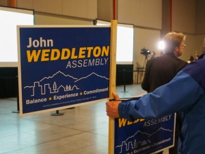 A John Weddleton supporter holding a sign shortly before the candidate was pronounced the winner in the South Anchorage race. (Photo by Zachariah Hughes/Alaska Public Media)